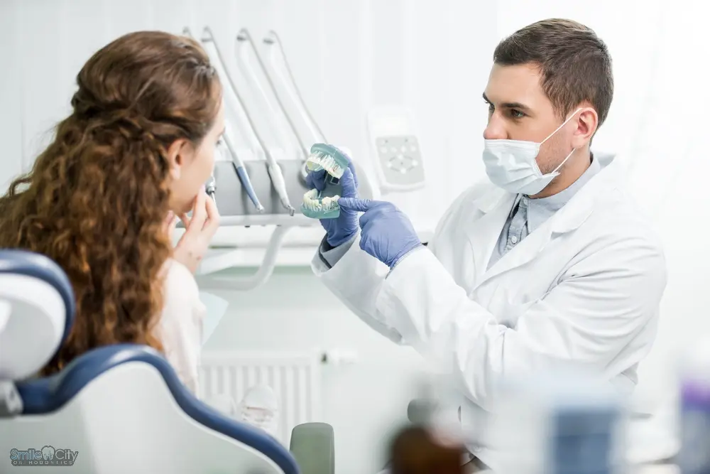 A dentist examining a patient's teeth during a consultation about how to fix overbite in Sunnyvale, TX in a clinic.