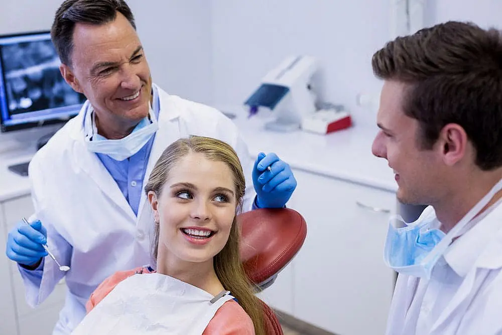 At Smile City Orthodontics in Sunnyvale TX, a dentist and assistant explain a Palatal Expander to a female patient seated in the dental chair.