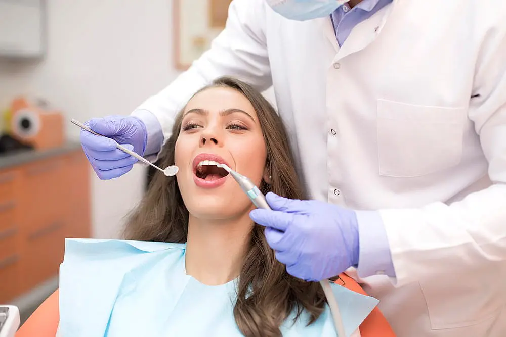At Smile City Orthodontics in Sunnyvale TX, a dentist uses dental instruments to check a patient's teeth for signs of tongue thrust.