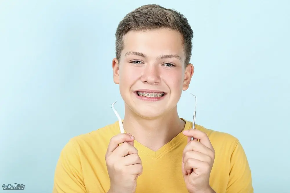 At Smile City Orthodontics in Sunnyvale TX, the modern waiting room features a white sofa, several black chairs, a wood-paneled accent wall, large windows, and a stylish ceiling light fixture. At Smile City Orthodontics in Sunnyvale TX, the modern waiting room features a white sofa, several black chairs, a wood-paneled accent wall, large windows, and a stylish ceiling light fixture.
