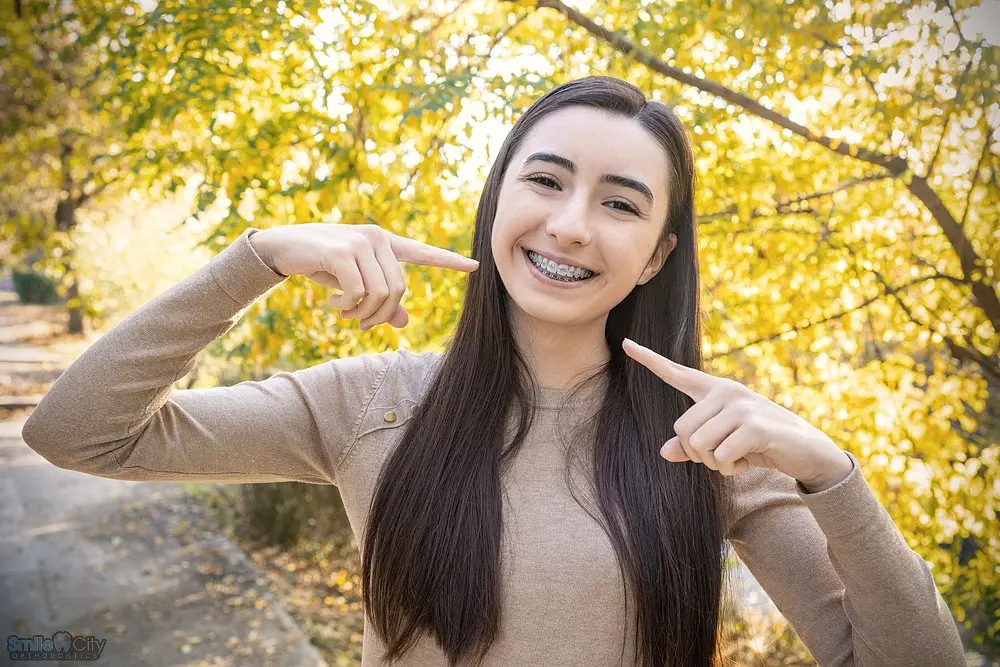 beautiful smiling girl showing metal braces teeth orthodontics dental theme - Clear Braces vs Metal Braces in Sunnyvale, TX