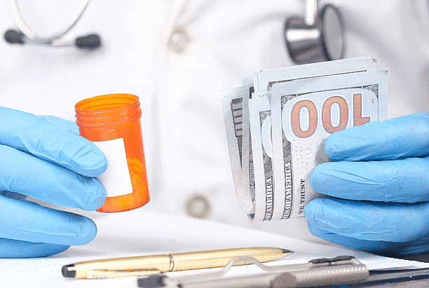 At Smile City Orthodontics in Sunnyvale TX, a healthcare professional in medical attire and blue gloves holds a pill bottle and a stack of hundred-dollar bills, symbolizing financial solutions such as an Invisalign payment plan.