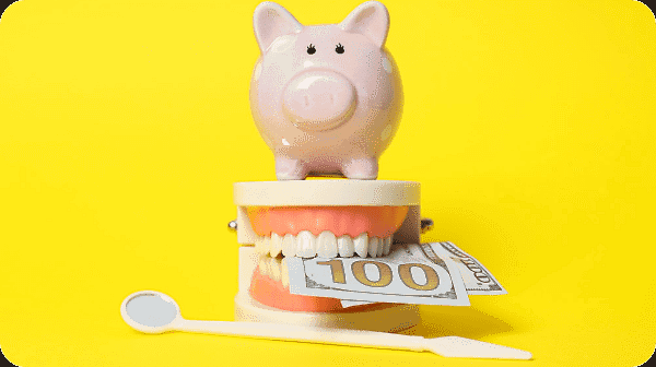 A pink piggy bank holding a $100 bill sits atop model teeth, next to a dental mirror, illustrating the savings offered by orthodontic insurance plans at Smile City Orthodontics in Sunnyvale TX, all set against a bright yellow background.