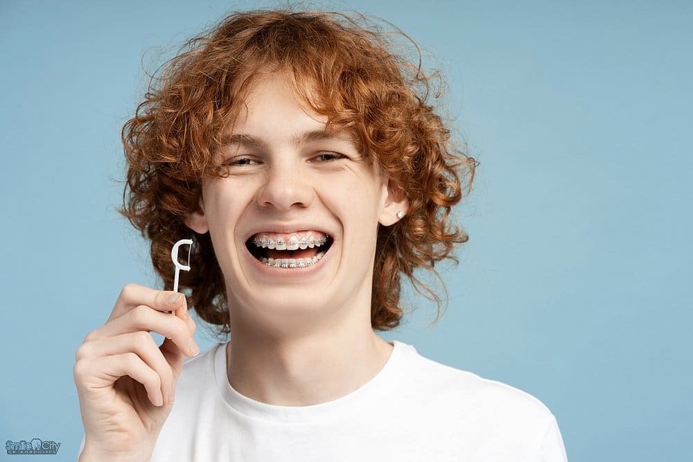 closeup image smiling teenager curly red hair metal braces - How to Floss with Braces in Sunnyvale, TX