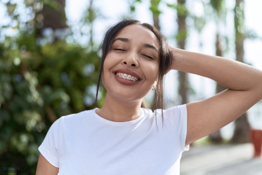 young arab woman with metal braces breathing closed eyes street - Aligners vs Braces in Sunnyvale, TX