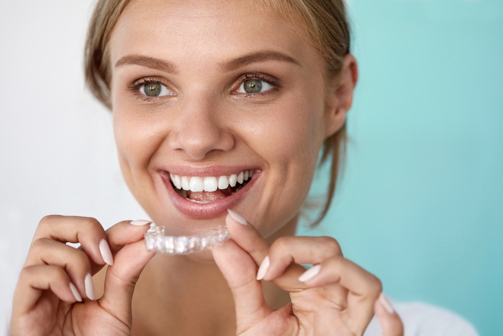 smiling woman with beautiful smile using invisalign clear aligners - How Long Does Invisalign Take? What the Timeline Really Depends On, Sunnyvale, TX