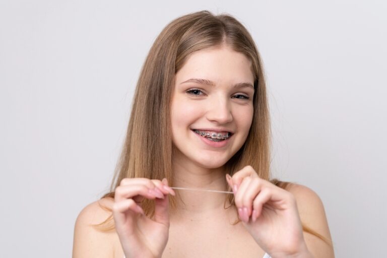 teenager russian girl with metal braces and floss isolated white background - How to Clean Braces: The Routine That Actually Protects Your Teeth in Sunnyvale TX