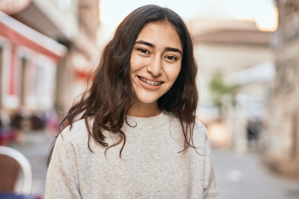 young middle east girl with metal braces smiling happy - How Long Does It Take To Get Used To Braces? A Week-by-Week Breakdown in Sunnyvale TX