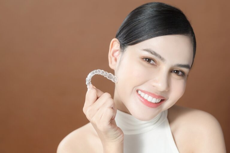 young woman beautiful teeth holding invisalign clear aligners healthy dental concept - How Long Does Invisalign Take? What the Timeline Really Depends On, Sunnyvale, TX